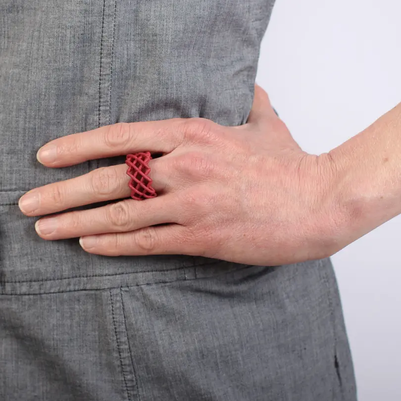 an einer Hand getragener moderne roter Ring aus Nylon
